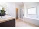 Bright bathroom with a soaking tub, glass enclosed shower, and a large window at 1390 Napa Valley Sw Dr, Lawrenceville, GA 30045