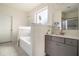 Bathroom featuring a tub, a separate shower, and modern vanity with ample storage at 182 Broder Farms Dr, Stockbridge, GA 30281