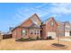 Attractive brick home with a well-maintained lawn, enhanced by a two-car garage and complementary stone details at 182 Broder Farms Dr, Stockbridge, GA 30281