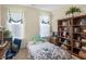 Bedroom with floral bedding, bookshelves, and a work space with natural lighting at 3226 Puritan Way, Mcdonough, GA 30252