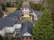 Aerial view of an expansive two-story brick home with a large backyard, a courtyard, and mature trees at , Roswell, GA 30075