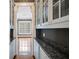 Butler's pantry with granite countertops, white cabinetry, and view to living area at , Roswell, GA 30075