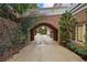 A large driveway leads through a brick archway to a two-story home with manicured landscaping at , Roswell, GA 30075