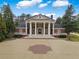Stately brick home with a large circular driveway, white columns, and manicured landscaping at , Roswell, GA 30075