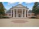 Two-story brick home with a grand entrance, classic columns, manicured landscaping, and a circular driveway at , Roswell, GA 30075