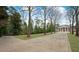 Traditional home showcasing an expansive driveway, meticulously manicured lawn, and mature trees at , Roswell, GA 30075
