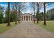 Grand two-story brick home with a long driveway, mature landscaping, and a stately entrance at , Roswell, GA 30075