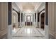 Grand foyer with marble floors, stately columns, chandelier, and dark-painted accent walls at , Roswell, GA 30075