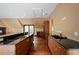 Well-lit kitchen with hardwood floors, wooden cabinets, and black countertops at , Roswell, GA 30075