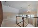 Upper landing area features a decorative chandelier, neutral carpeting, and windows with wooden shutters at , Roswell, GA 30075