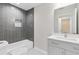 Modern bathroom featuring gray tiled walls, a bathtub, and a vanity with sleek countertops at 5115 N Pratt St, Covington, GA 30014