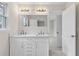 Bathroom with double vanity, stone countertops, white cabinets, and door leading to additional room at 5115 N Pratt St, Covington, GA 30014