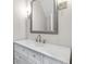 Bathroom with a white vanity, marble countertop, and a decorative mirror, showcasing modern fixtures at 5115 N Pratt St, Covington, GA 30014