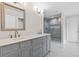 Bathroom with double vanity, stone countertops, and a glass-enclosed shower with marble tile at 5115 N Pratt St, Covington, GA 30014