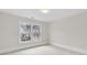 Bright bedroom with neutral walls and carpet, a flush light, and a large window overlooking the neighborhood at 5115 N Pratt St, Covington, GA 30014