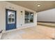 Covered entry showcasing a stylish blue door, white brick accents, and view of the front yard at 5115 N Pratt St, Covington, GA 30014