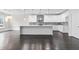 Spacious kitchen featuring white cabinetry, a large island, stainless steel appliances, and designer backsplash at 5115 N Pratt St, Covington, GA 30014