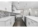 Modern kitchen with white cabinets, stainless steel appliances, quartz countertops, and a stylish backsplash at 5115 N Pratt St, Covington, GA 30014