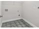 Utility room with gray tile flooring, wire shelf, and necessary hookups at 5115 N Pratt St, Covington, GA 30014