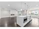 Open-concept living space with a fireplace, kitchen island with sink, and views of the well-manicured front yard at 5115 N Pratt St, Covington, GA 30014