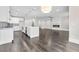 Open-concept living space featuring a modern fireplace, hardwood floors, and a bright kitchen with an island at 5115 N Pratt St, Covington, GA 30014