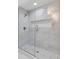 Glass shower featuring marble tile surround, a mosaic tile niche, and modern fixtures at 5115 N Pratt St, Covington, GA 30014