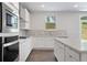 Bright kitchen with white cabinets, stainless steel appliances, and a large center island at 910 Melody Ct, Buford, GA 30518