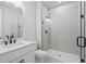Bathroom featuring a walk-in shower and sleek vanity with black hardware accents at 910 Melody Ridge Ln, Buford, GA 30518