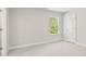 Inviting bedroom featuring plush carpet, a window with trees, and a minimalist interior design at 910 Melody Ridge Ln, Buford, GA 30518