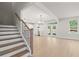 Staircase leading to an open-concept living space with kitchen, dining, and backyard views at 910 Melody Ridge Ln, Buford, GA 30518