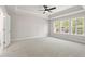 Spacious main bedroom with tray ceiling, carpeted floors, and large windows with wooded views at 910 Melody Ridge Ln, Buford, GA 30518