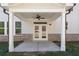 Covered patio with ceiling fan, brick accents, and double doors enhances outdoor living space at 910 Melody Ridge Ln, Buford, GA 30518