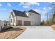 Large concrete driveway leading to a two-car garage with wooden doors, set against white brick at 2711 Twisted Oak Ne Ln, Marietta, GA 30066