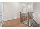 Upstairs hallway features hardwood floors, wood railing with metal spindles, and neutral wall paint at 2711 Twisted Oak Ne Ln, Marietta, GA 30066