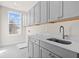 Laundry room with gray cabinets, white countertop, and stainless steel sink at 2711 Twisted Oak Ne Ln, Marietta, GA 30066