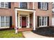 Inviting front porch with a red door, brick walkway, and black mulch at 5485 Brookstone Nw Dr, Acworth, GA 30101