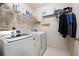 Functional laundry room with modern washer, dryer and wire shelving for storage solutions at 5485 Brookstone Nw Dr, Acworth, GA 30101