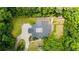 Aerial view of the property showcasing the home's layout, surrounding greenery, and expansive driveway at 11260 Houze Rd, Roswell, GA 30076