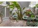 Bright atrium features lush tropical plants, stone floors, and comfortable seating for relaxed living at 11260 Houze Rd, Roswell, GA 30076
