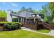 Exterior view of the home's backyard with a spacious deck, green lawn, and surrounding trees, perfect for outdoor living at 11260 Houze Rd, Roswell, GA 30076