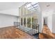 Bright hallway with hardwood floors and large windows overlooking an interior atrium at 11260 Houze Rd, Roswell, GA 30076