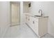 Laundry room with white cabinetry, granite countertops and tiled floor at 11260 Houze Rd, Roswell, GA 30076