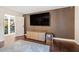 Modern living room with hardwood floors, a large TV, and an open doorway leading to the outdoor courtyard at 11260 Houze Rd, Roswell, GA 30076