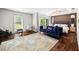 Spacious bedroom with wood floors, area rug, sleek lighting fixture, and serene views of surrounding greenery at 11260 Houze Rd, Roswell, GA 30076