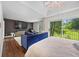 Bright main bedroom featuring hardwood floors, a tray ceiling, and a sliding glass door leading to a private balcony at 11260 Houze Rd, Roswell, GA 30076