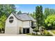 Rear exterior features a large garage and unique architectural details, with a stone base and decorative round window at 11260 Houze Rd, Roswell, GA 30076
