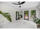 Bright sun room featuring sleek black ceiling fan, large windows, and lush plants at 11260 Houze Rd, Roswell, GA 30076