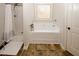 Well-lit bathroom featuring a soaking tub, separate shower, tiled floors, and a white door at 139 6Th St, Auburn, GA 30011