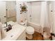 This bathroom offers a tub shower, toilet, vanity with sink, mirror and decorative shelves at 139 6Th St, Auburn, GA 30011