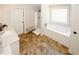 Bright bathroom featuring a soaking tub, separate shower, vanity with sink, and tiled floor at 139 6Th St, Auburn, GA 30011